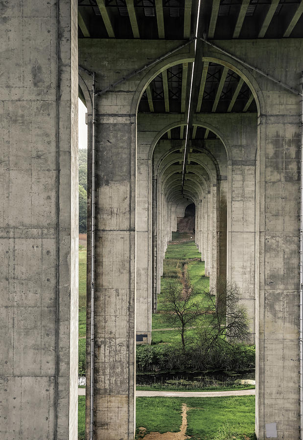 Repeated concrete arches beneath the Ohio Turnpike bridge in the Cuyahoga Valley region