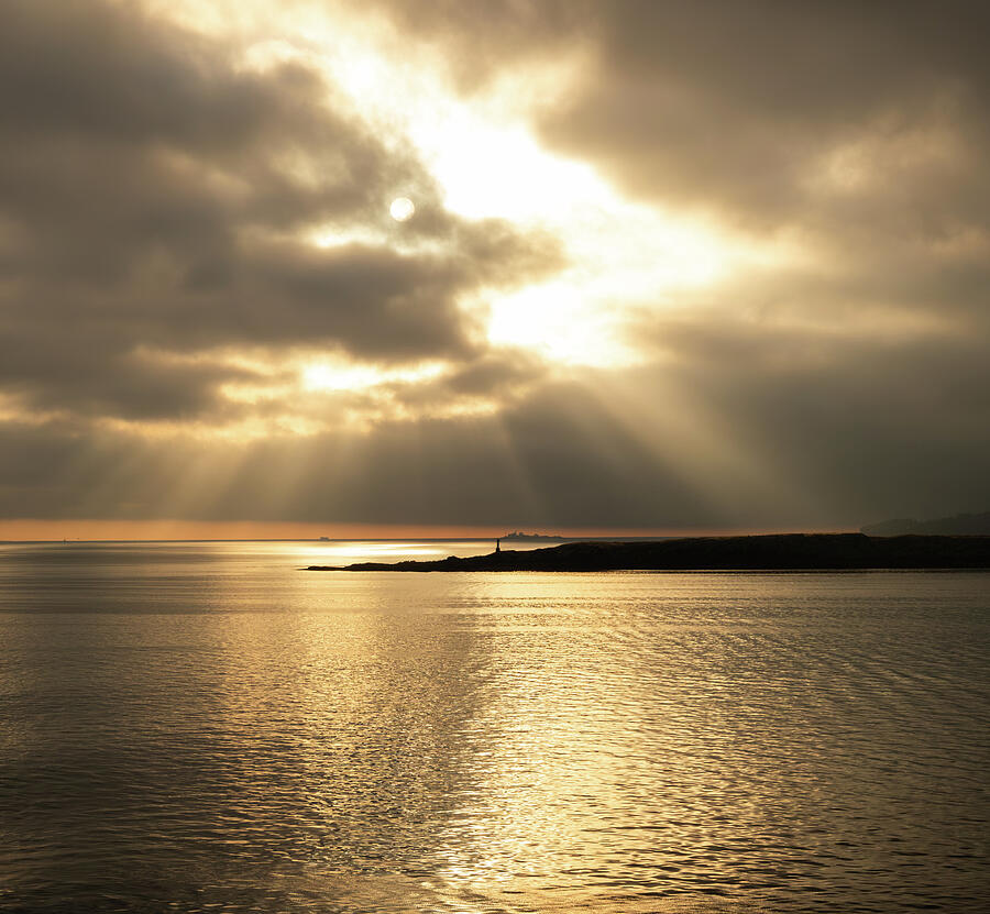 Golden sunlight breaking through clouds over the Strait of Georgia on Vancouver Island