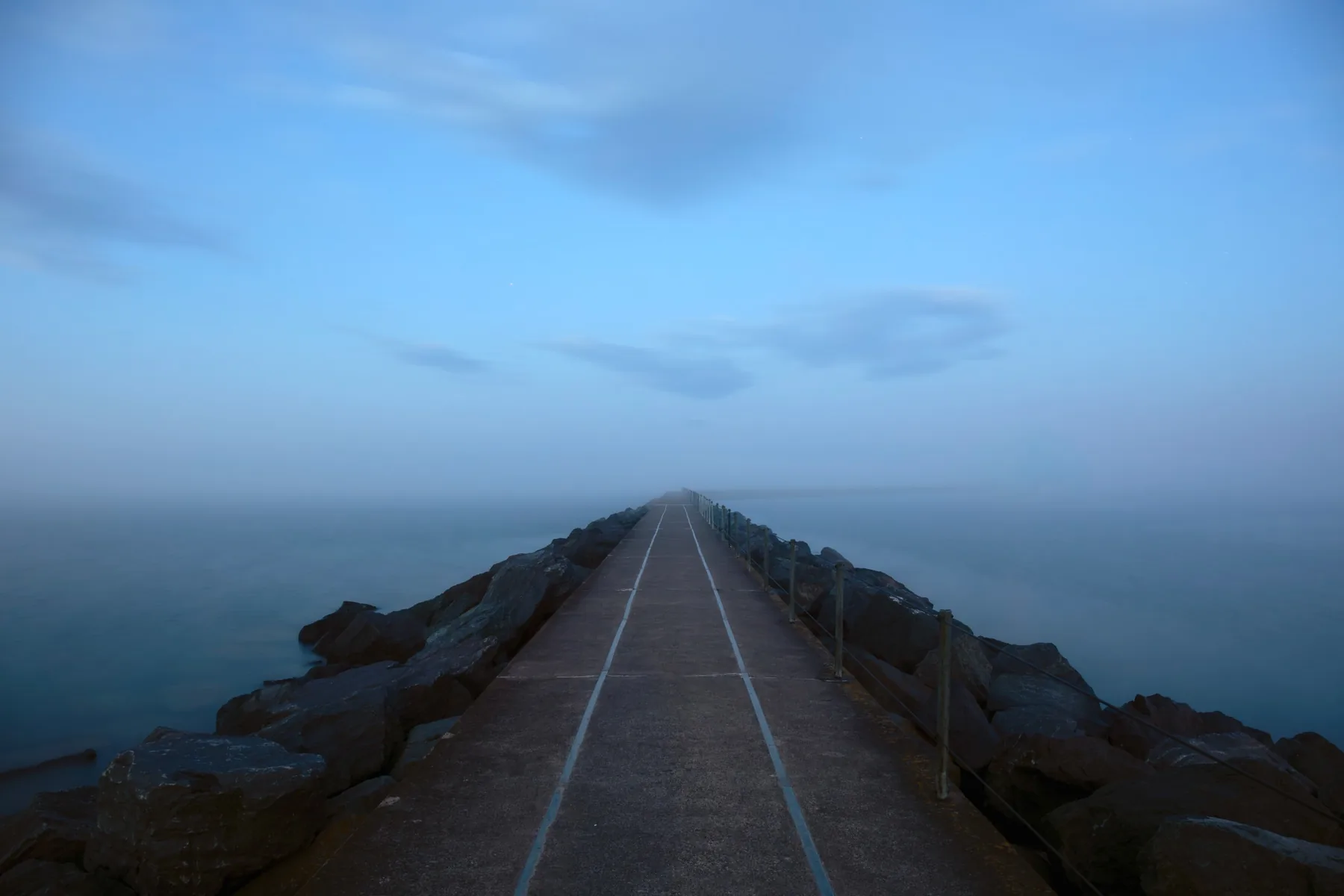 Minimal foggy walkway disappearing into Lake Superior