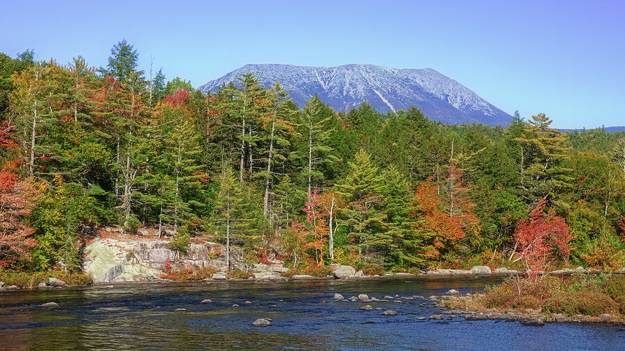 Mount Katahdin rising above autumn forest and water in Baxter State Park Maine