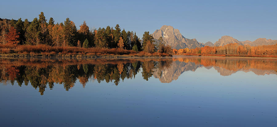 Mount Moran and autumn trees reflected in calm water at Oxbow Bend in Grand Teton National Park
